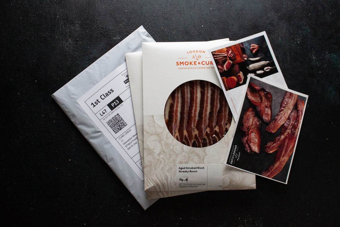 A London Smoke & Cure subscription pack with 2 packs of bacon and inserts with information about this month's bacon variety.