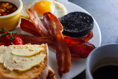 A close up of a full English breakfast focusing on London Smoke & Cure's Aged Smoked Streaky Bacon.